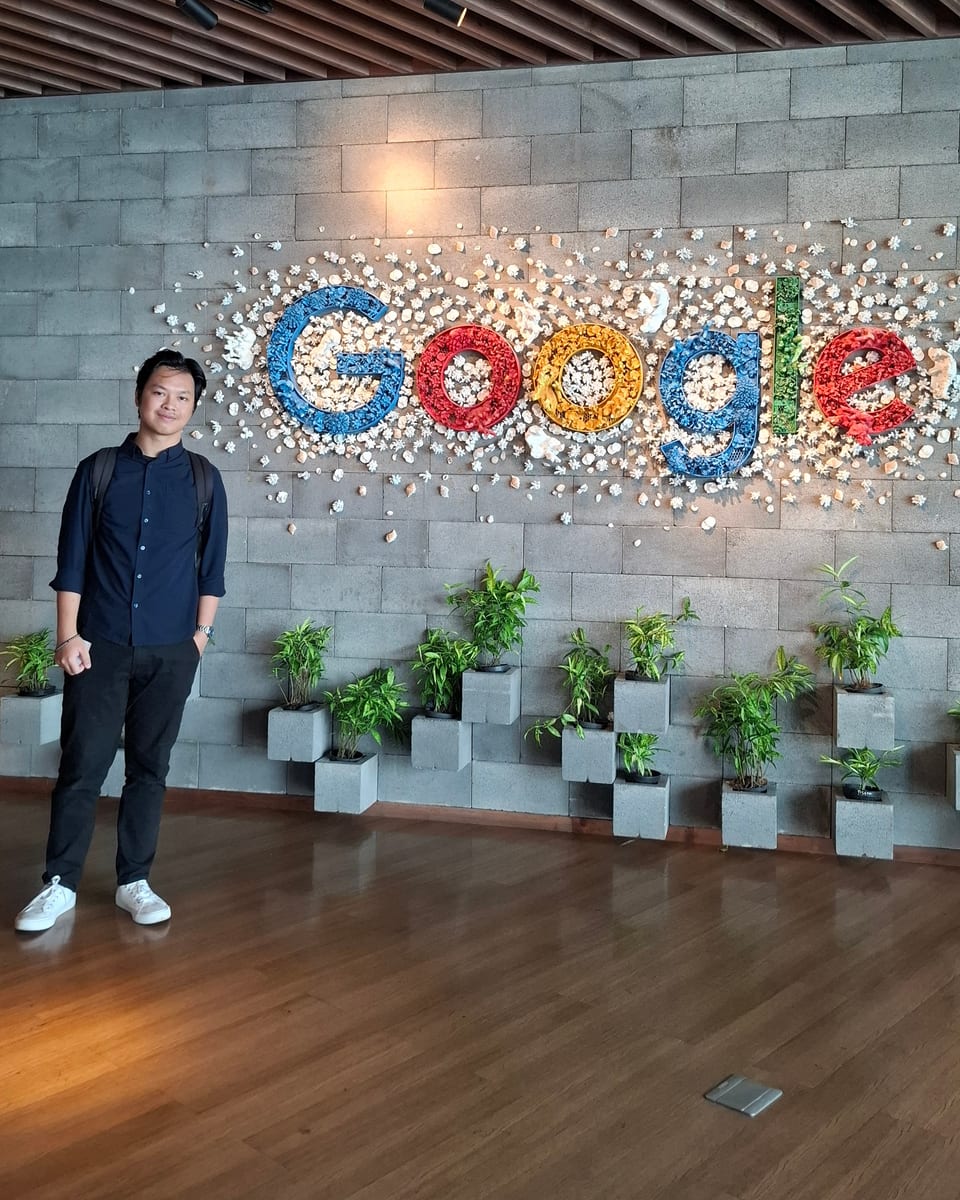 Keindra Bagas Maulana, standing beside a Google letter wall built from painted stones